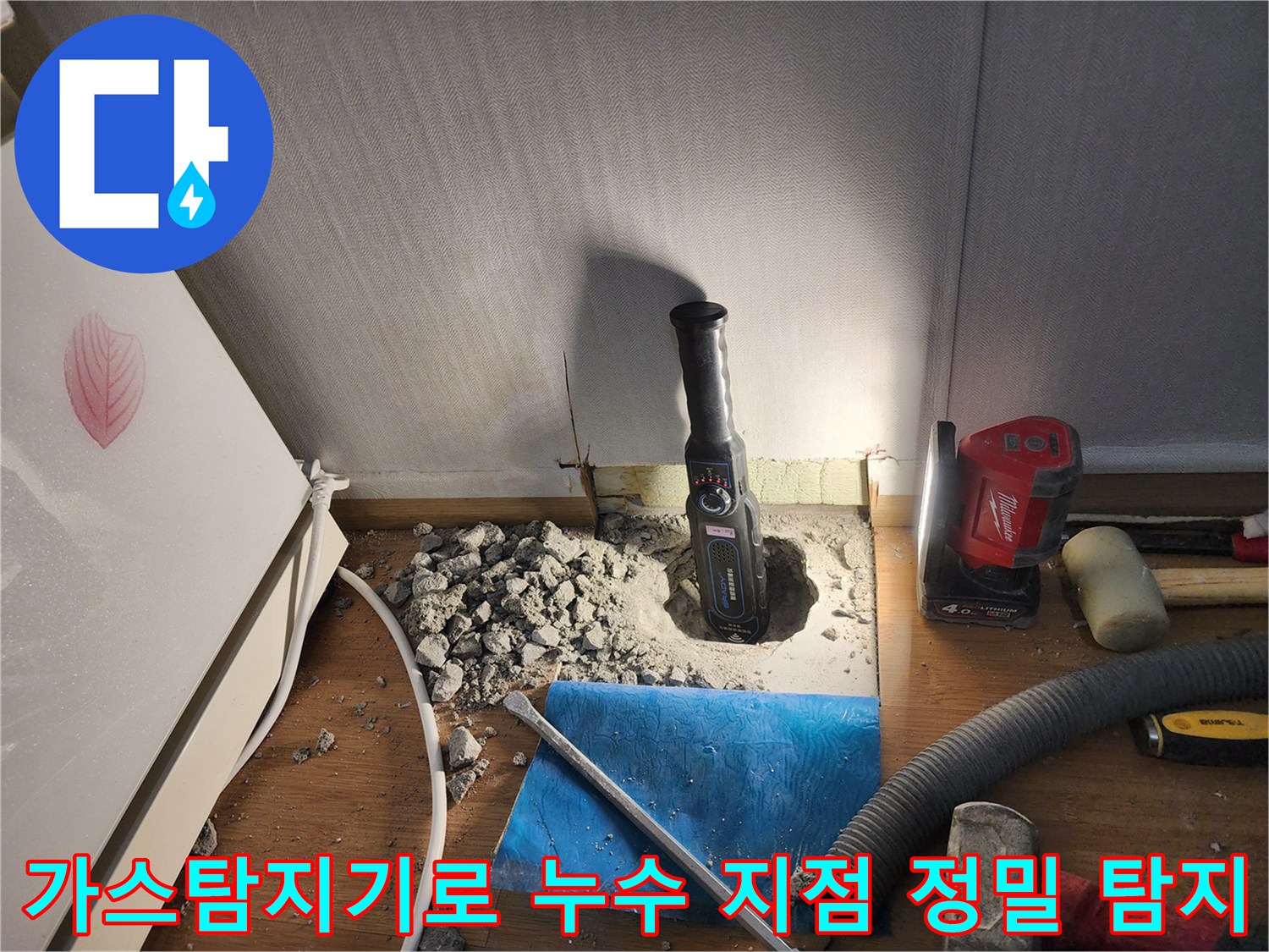 가스 탐지기를 사용하여 바닥 아래 배관 누수 위치를 파악하는 모습