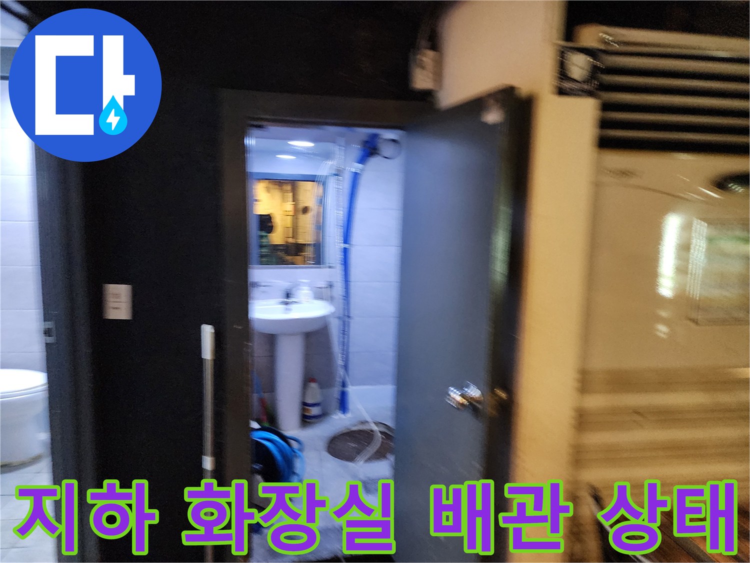 지하 화장실 내부에 노출된 파란색 주름관과 세면대 하부 배관 모습