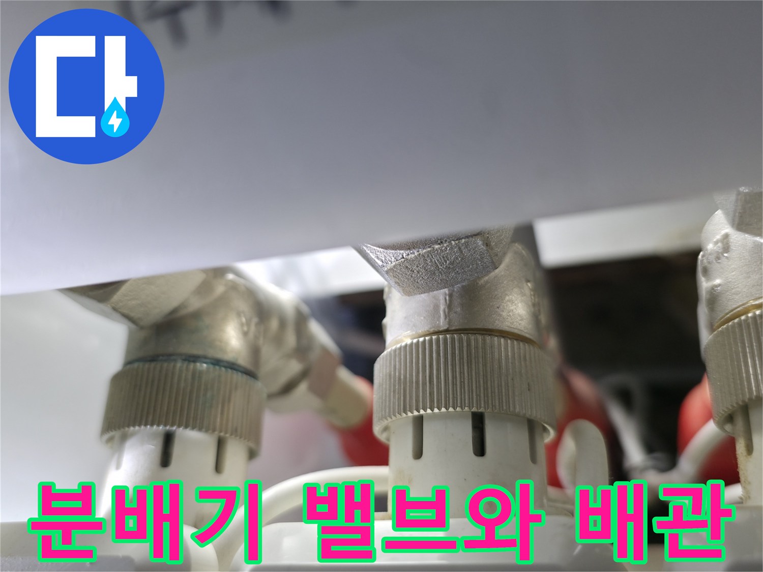 난방 분배기 부품 - 은색 금속 재질의 밸브와 흰색 연결 소켓 상세