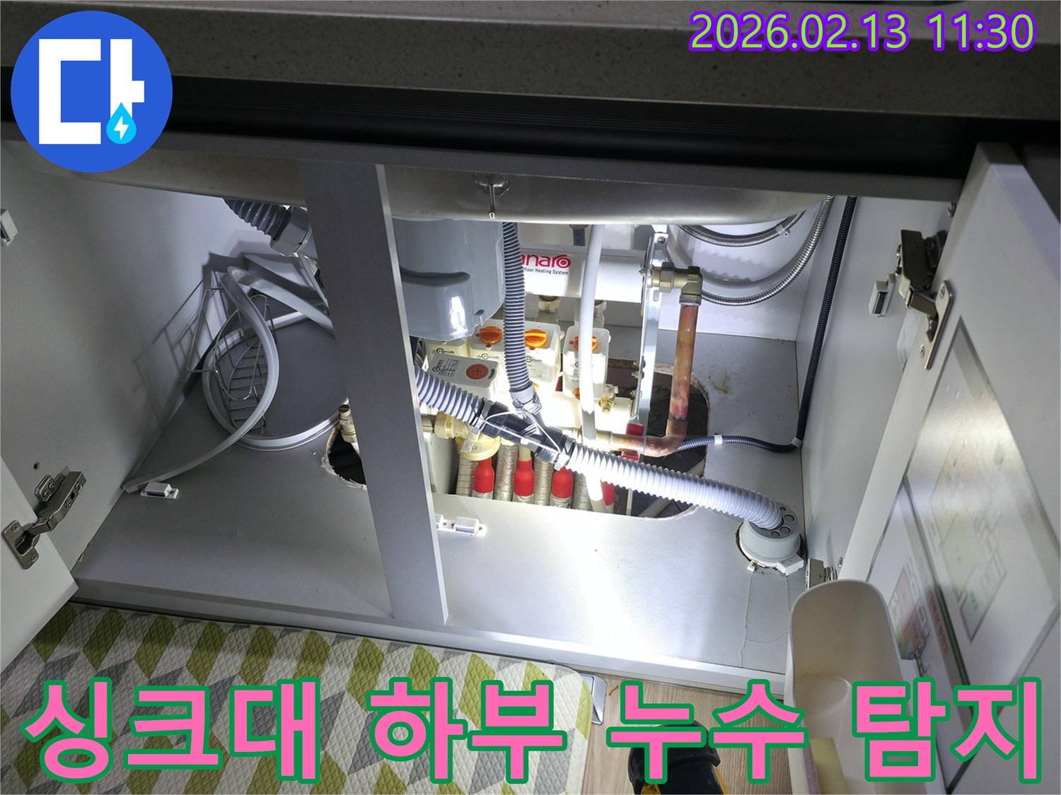 싱크대 하부의-어둡고 좁은 공간을-손전등으로 밝히며-누수 지점을 정밀하게-탐지하는 전문가의 모습