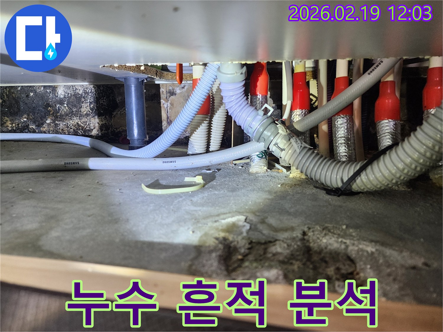 싱크대 하부의 배관 주변에 남아있는-오래된 물자국과 곰팡이 흔적을-전문가가 정밀하게 분석하는 모습입니다
