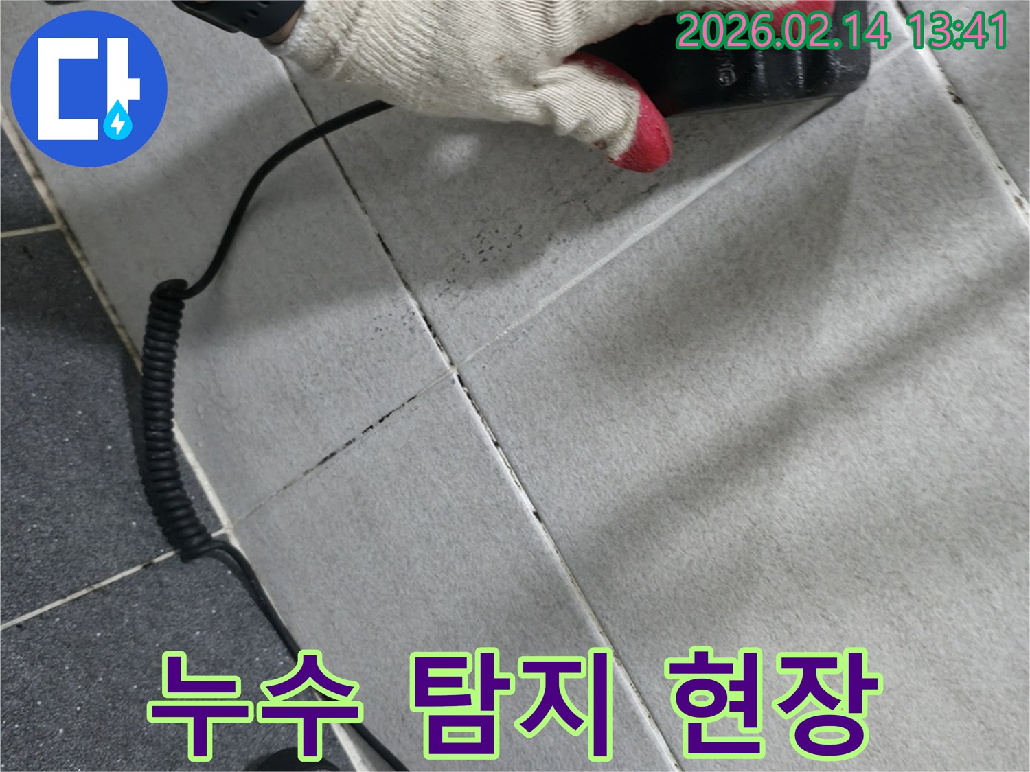 누수 탐지 전문가가-벽면에 장비를 대고-누수 여부를-확인하는 작업 장면