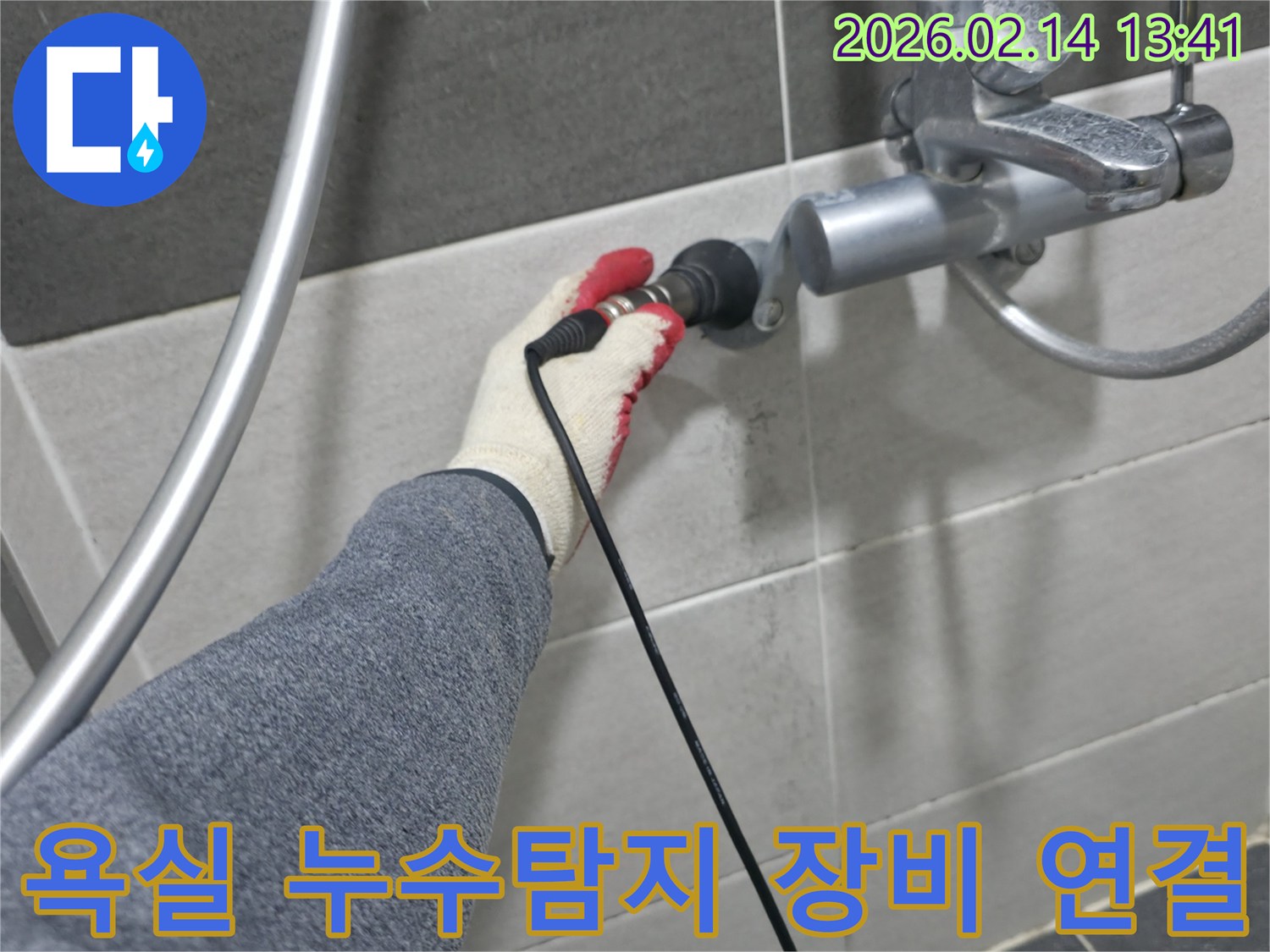 전문 엔지니어가-장갑을 낀 손으로-욕실 수도꼭지에-누수 탐지 장비를 연결하는 모습입니다
