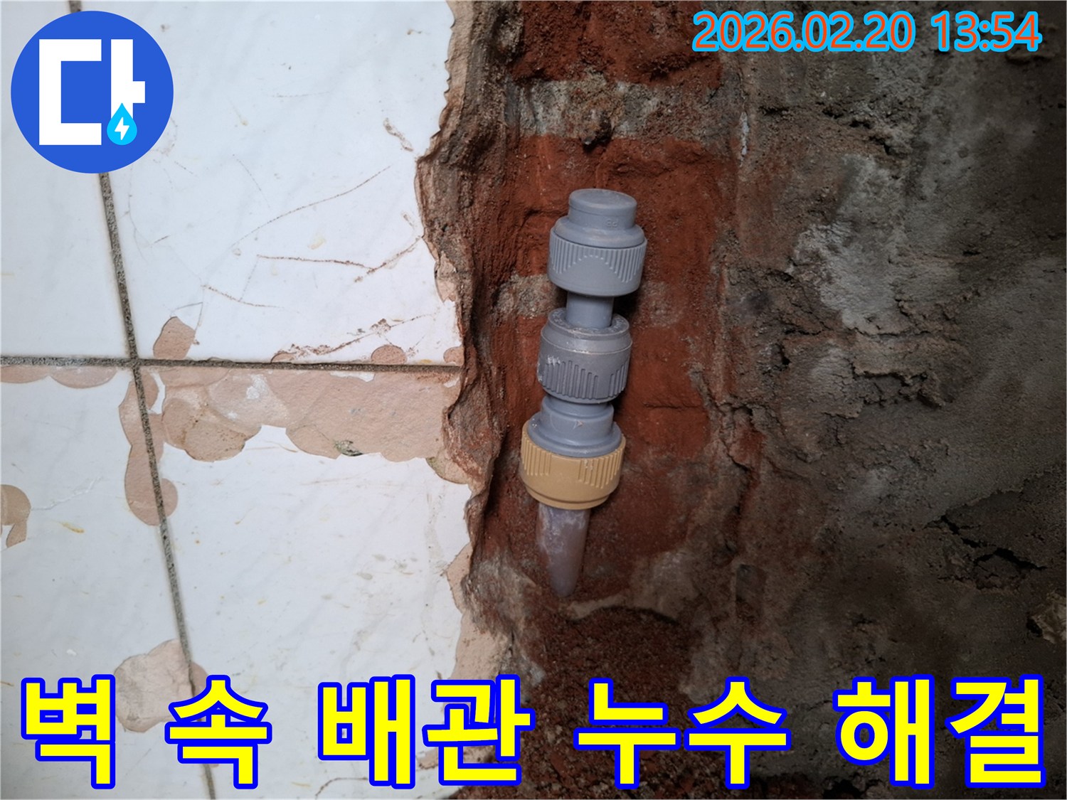 벽을 개방하여-드러난-수도배관의-누수 지점을-새로운 연결 부품으로-해결하는-작업 현장입니다.