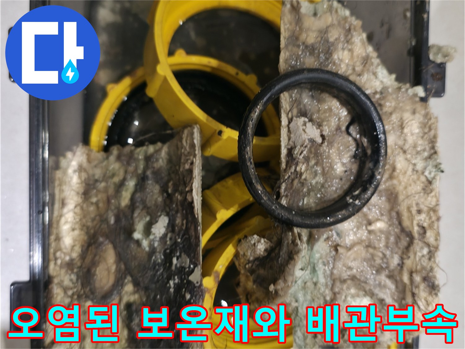 누수로 인해 젖고 오염된 배관 보온재와 노란색 배관 부속의 모습