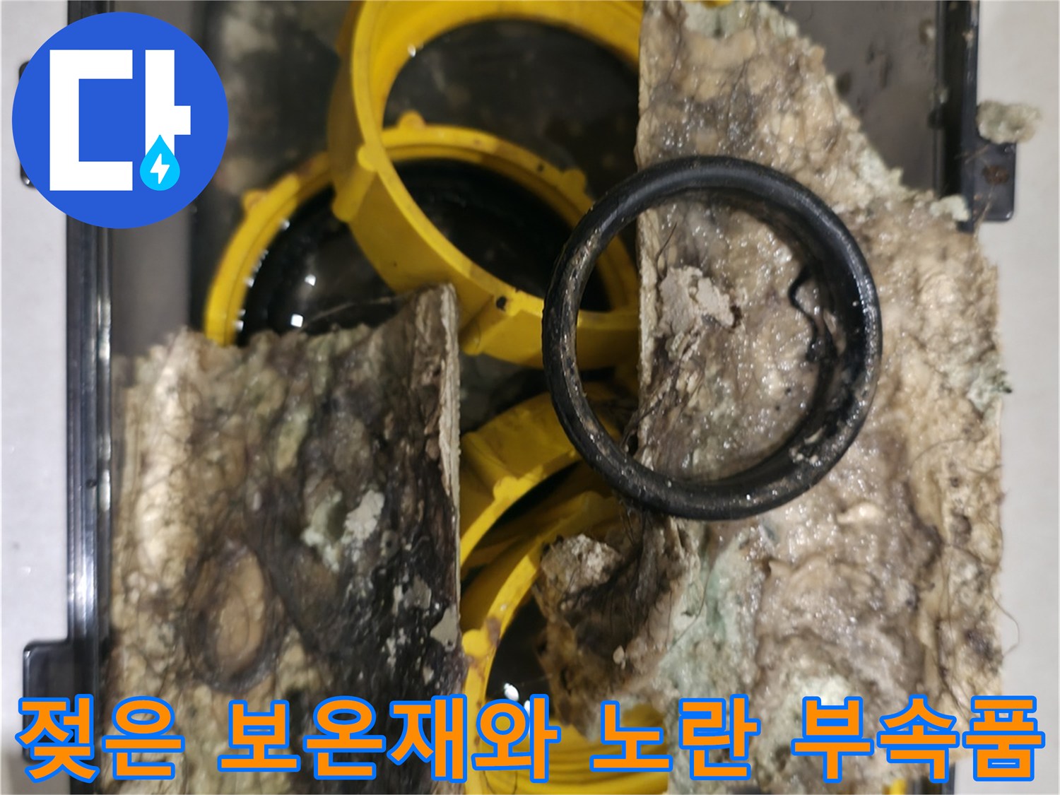 물에 젖어 검게 변한 보온재와 노란색 배관 연결 부품
