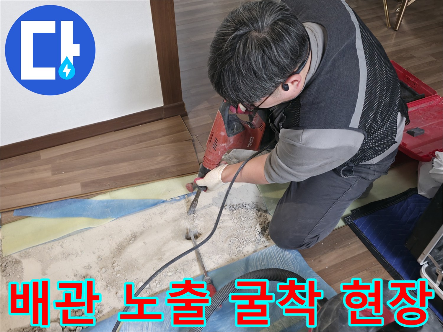 작업자가 거실 마루를 들어낸 자리에서 바닥을 파내고 있는 장면