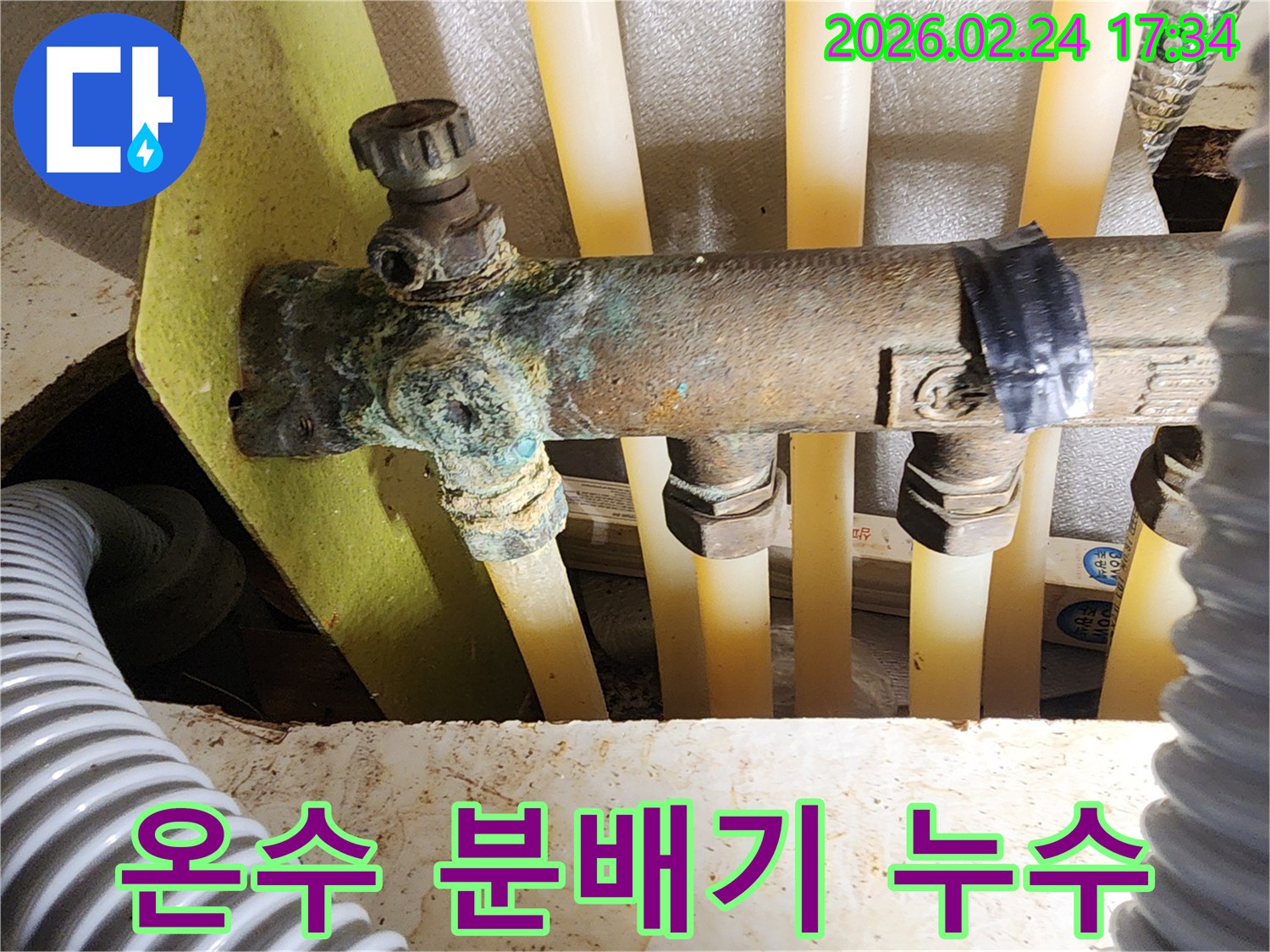 이 이미지는 빌라 온수 분배기의 배관에서-발생한 심각한 부식과-그로 인한 누수 흔적을 보여주며-전문적인 수리가 필요함을 나타냅니다.