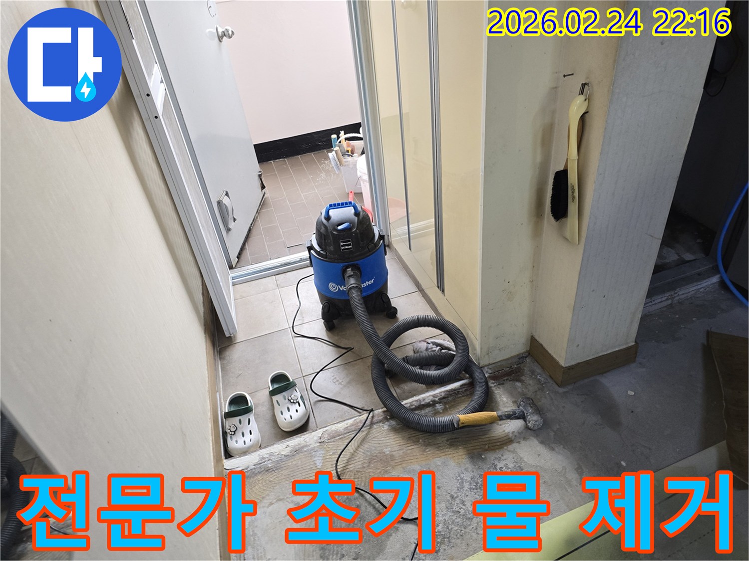 누수 현장에서-전문가의 노하우로-습식 청소기를 사용하여-바닥의 물기를-효과적으로 제거하는 모습