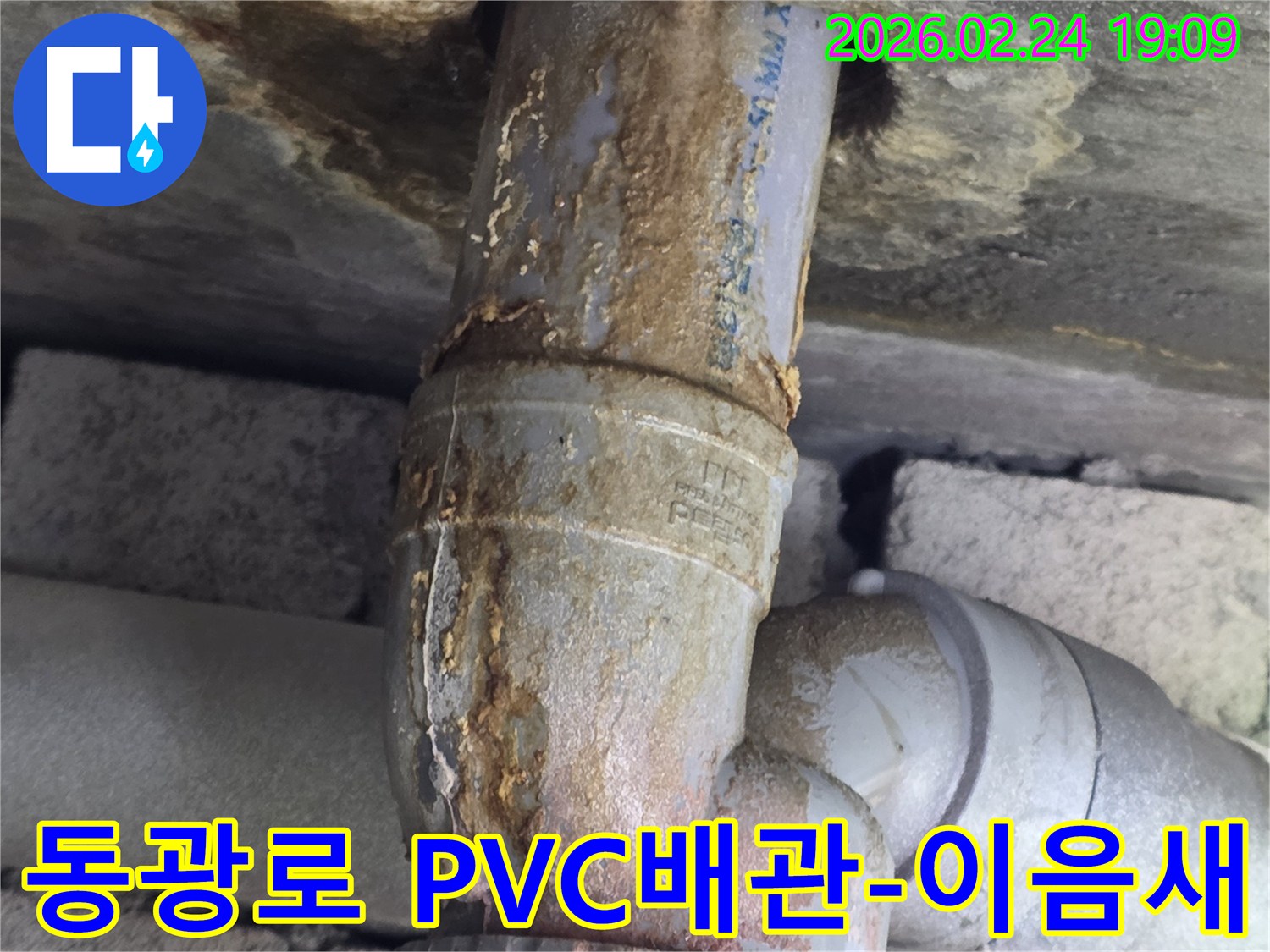 PVC 배관의-연결 부위에서-누수가 발생하여-부식된 물때가-흐르고 있는-상황을 보여줍니다.