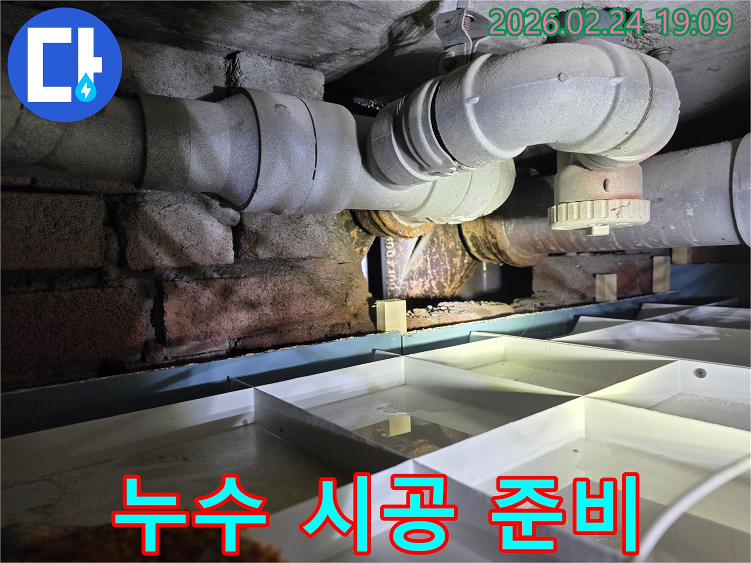 건물-하부의-배관에서-발생한-누수-지점을-확인하고-보수-시공을-준비하는-현장-사진