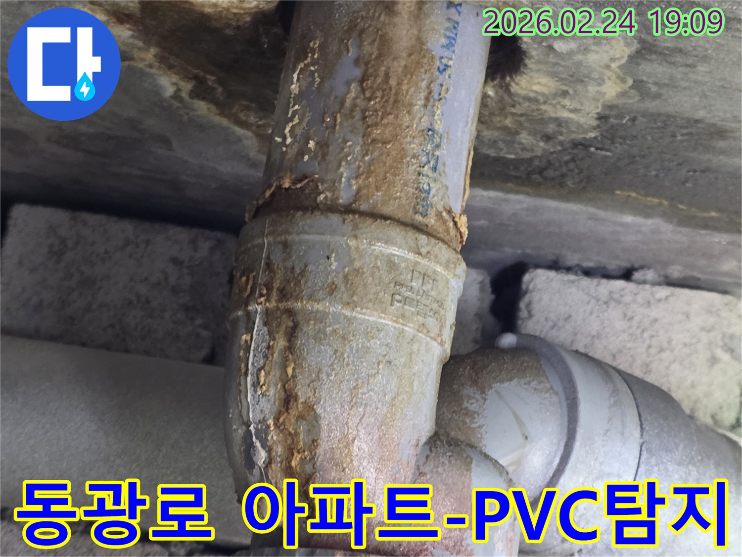 아파트 PVC 배관에서-누수가 발생하여-주변에 부식된-물때가-묻어있는-현장 사진입니다.