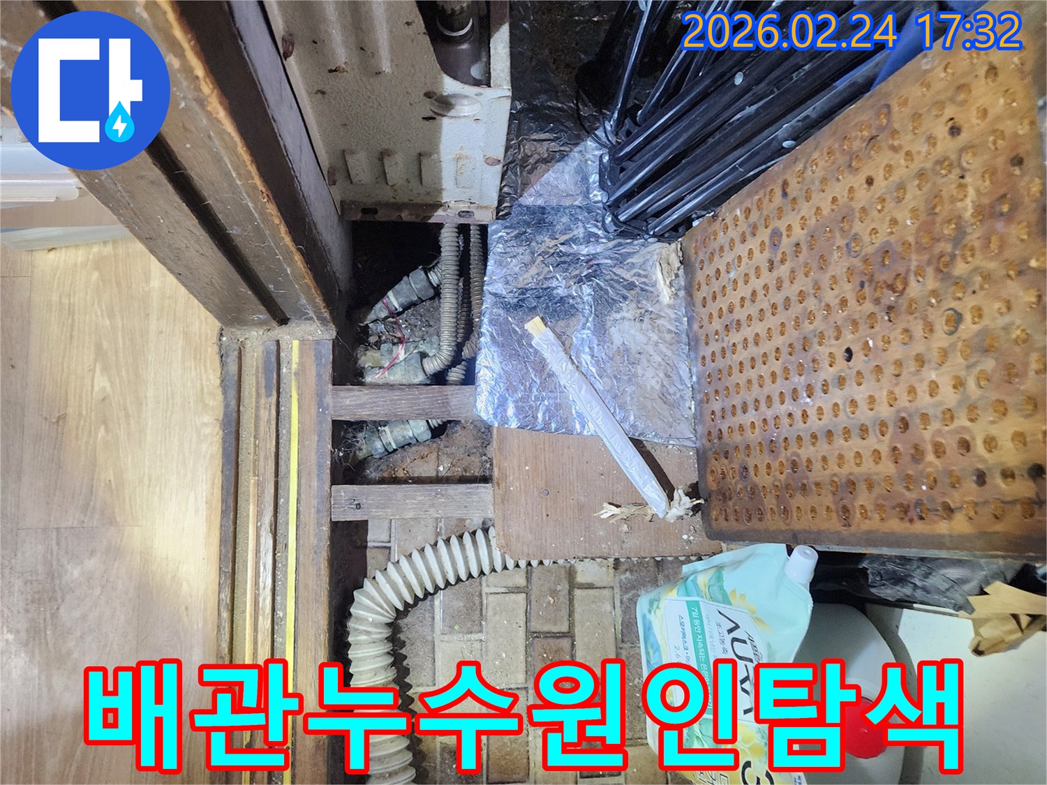 좁고 복잡한 공간에서-오래된 배관의 누수 흔적을-전문가가 면밀히 확인하는 사진입니다