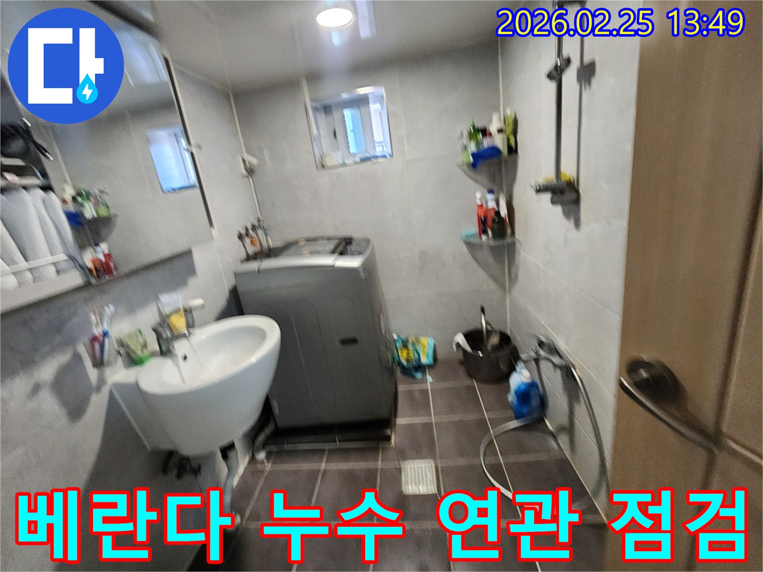 세탁기가-있는-욕실-공간에서-베란다-누수와-연결될-수-있는-배관을-점검하는-모습을-담은-사진