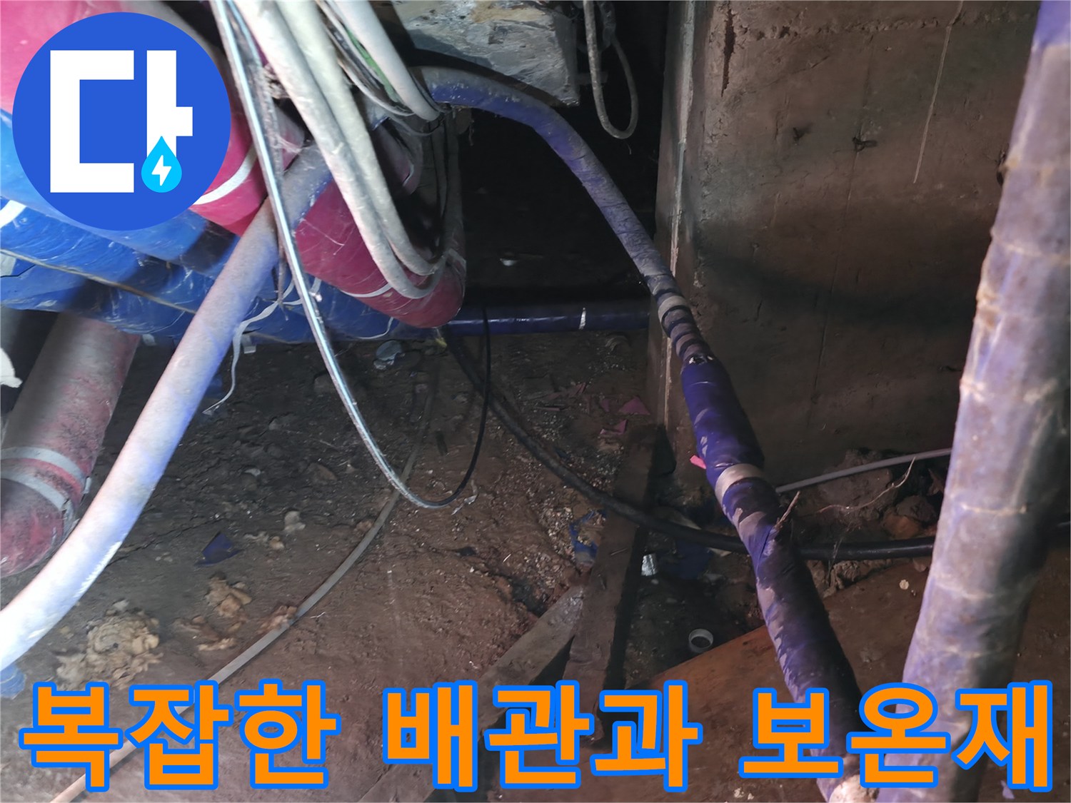 보온재와 테이핑 처리가 된 지하 배관실의 복잡한 배관 라인