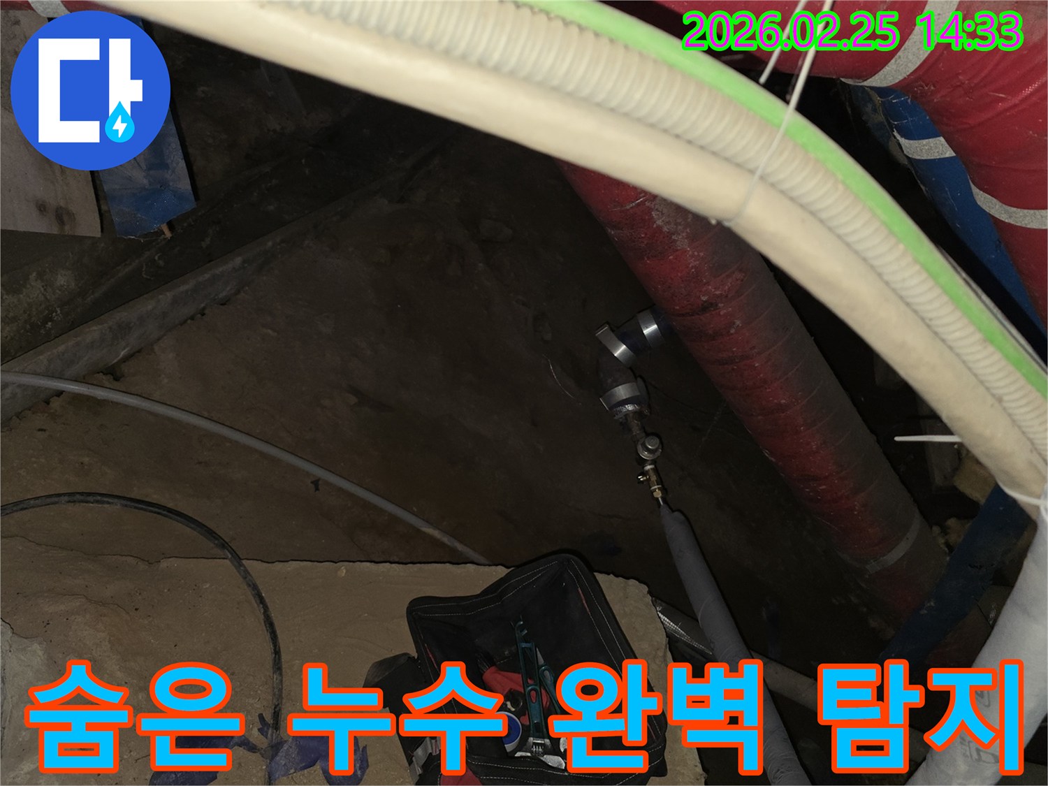 보이지 않는 곳의 누수까지 완벽하게 찾아내기 위해-배관에 정밀 탐지 장비를 연결하는-전문가의 작업 현장입니다.