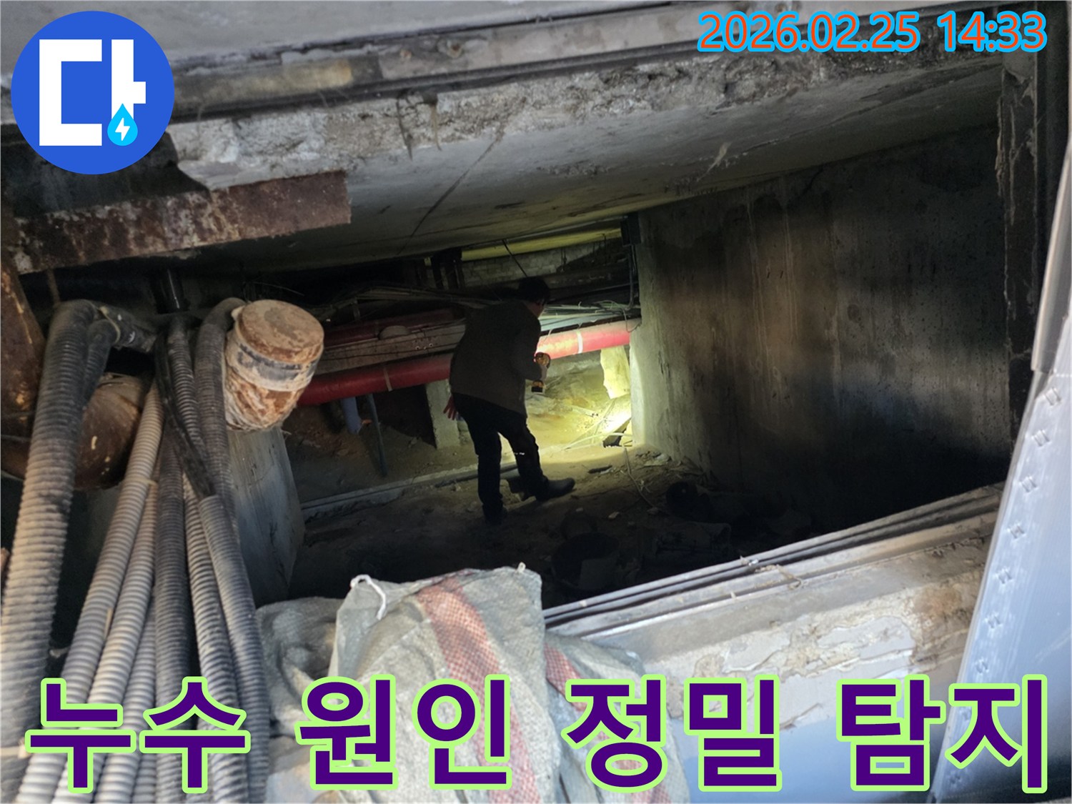 손전등을 든-누수 전문가가-복잡한 배관 사이에서-누수 지점을-확인하는 중