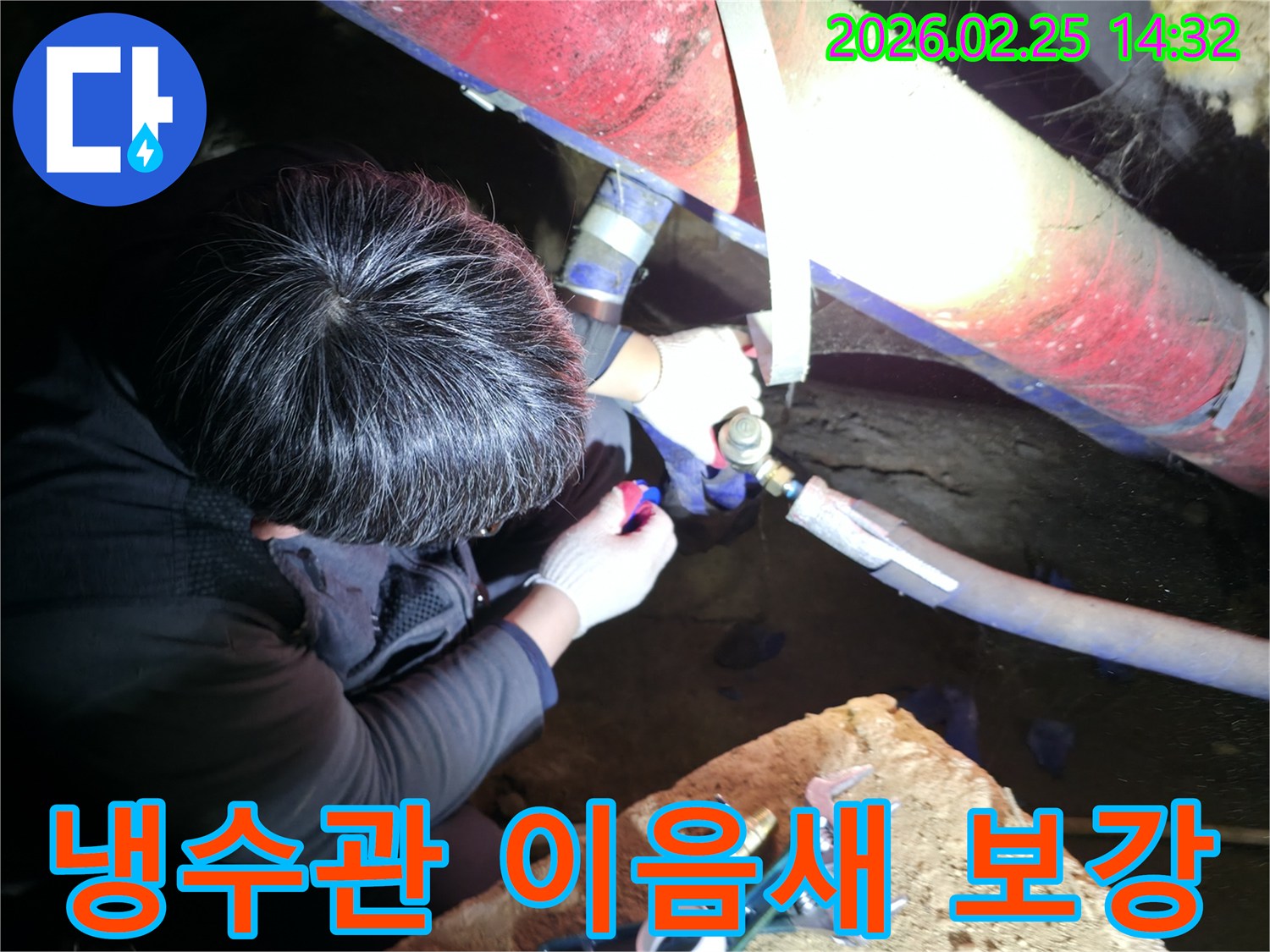 숙련된 누수 기술자가 좁은 공간에서 손전등을 비추며 냉수관-이음새 부위를 정밀하게 점검하고-압력 테스트 후 보강하고 있습니다-냉수누수해결-전문가보수