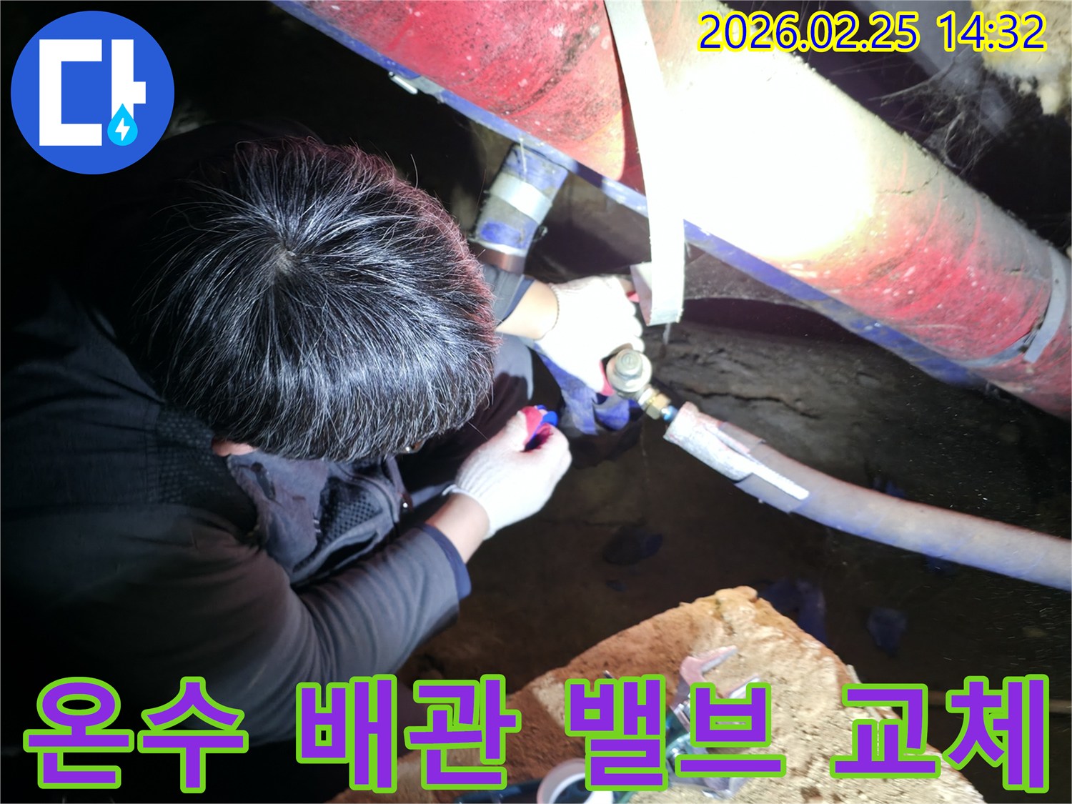 숙련된 누수 기술자가 좁은 공간에서 손전등을 비추며 온수-배관 밸브를 정밀하게 점검하고-꼼꼼하게 교체하고 있습니다-온수누수해결-전문가수리