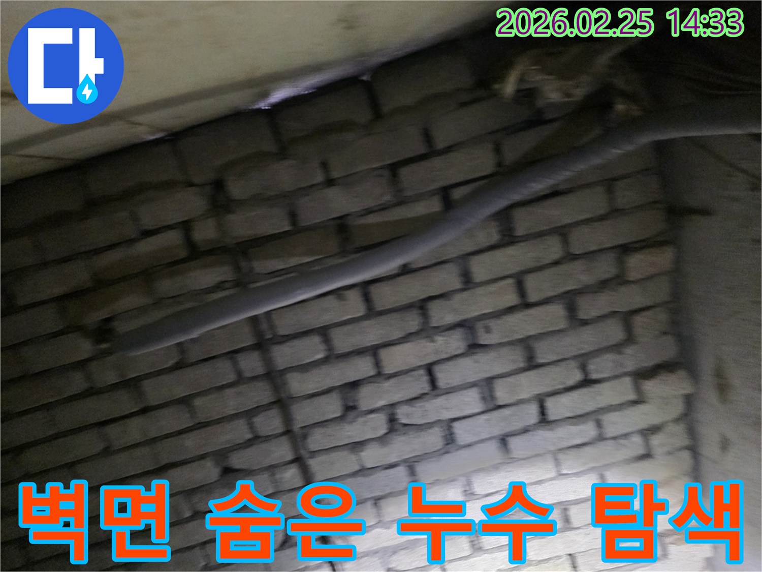 어두운 벽돌 벽면을 배경으로-단열재로 감싸인 배관에서-숨겨진 누수 원인을-찾기 위해 촬영된 현장 이미지입니다.