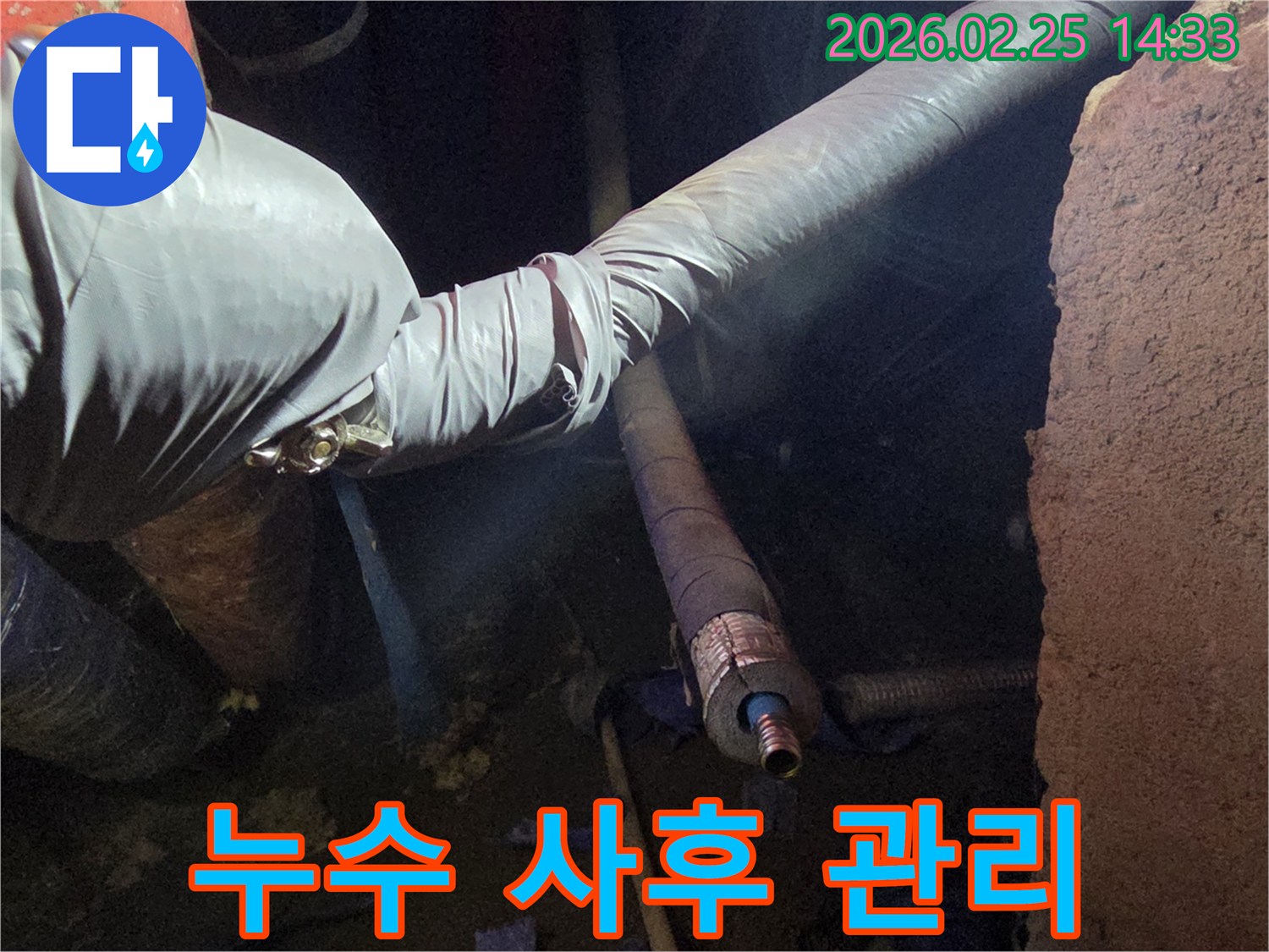어두운 작업 공간에서-장갑을 낀 손이-누수 수리 후-배관 상태를-최종적으로 점검하며-고객 만족을 위한-사후 관리를-진행하는 모습입니다