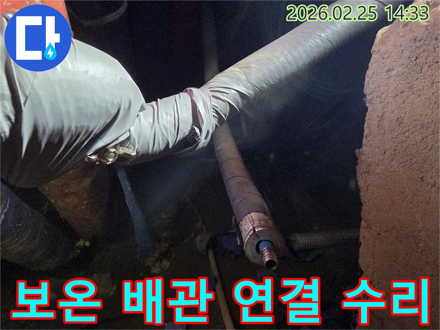 어두운 작업 공간에서-장갑을 낀 손이-보온재로 감싸진 배관의-연결 부위를-정밀하게 수리하는-모습입니다