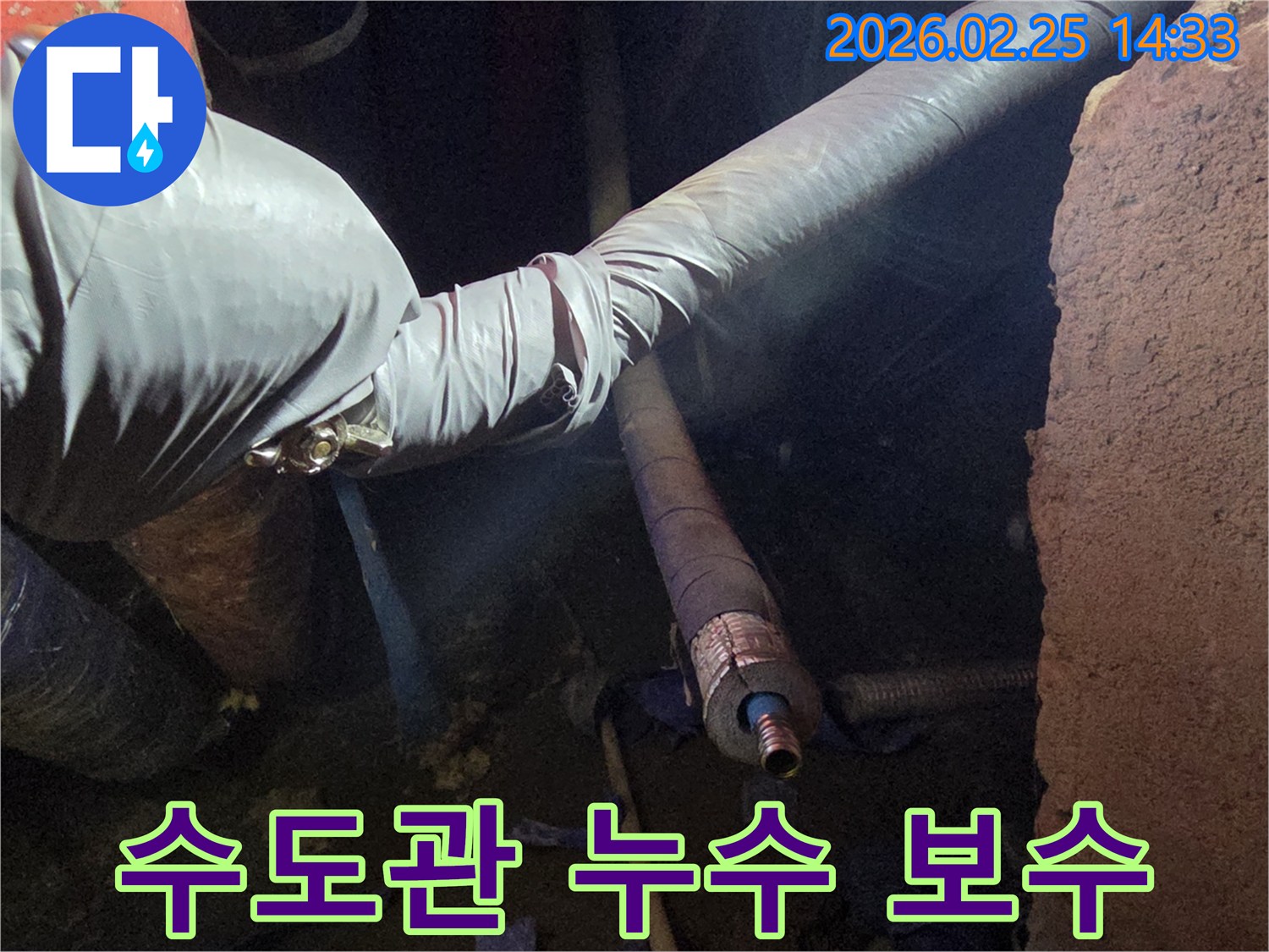 어두운 작업 공간에서-장갑을 낀 손이-손상된 수도관의-연결 부위를-세심하게 점검하며-수리 작업을-준비하는 모습입니다