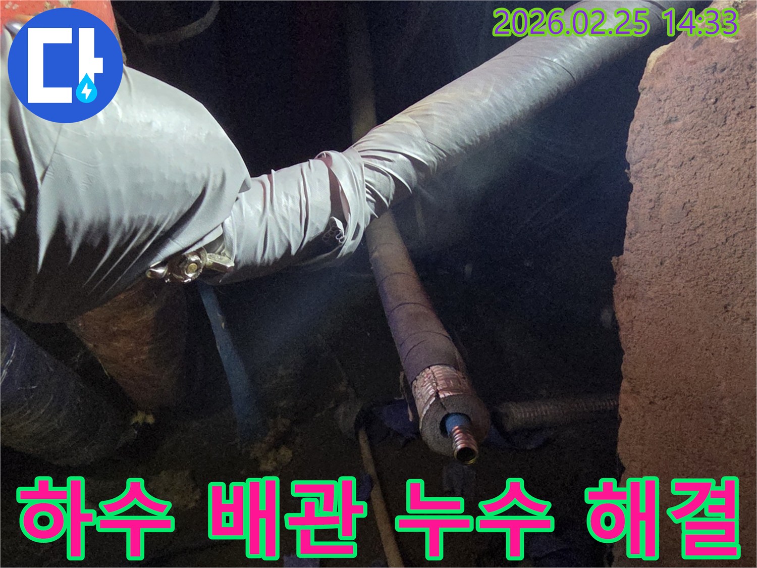 어두운 작업 공간에서-장갑을 낀 손이-하수 배관의-손상된 연결 부위를-세심하게 점검하며-누수 원인을-확인하고-해결하는 모습입니다