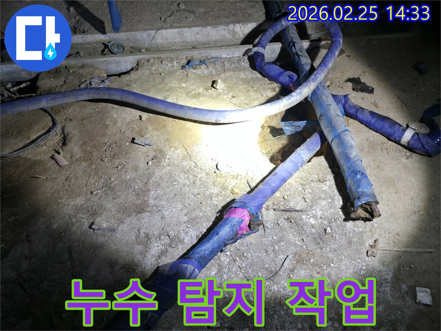 어두운 지하에서-누수 지점을 찾기 위해-배관을 확인하는 전문가의 모습입니다.