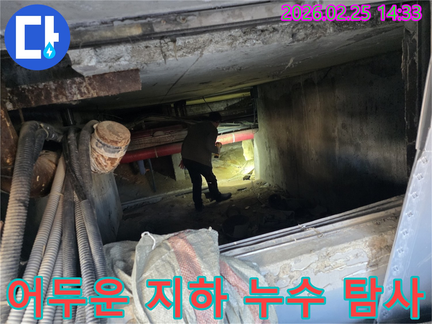어둡고 좁은-지하 공간에서-누수 엔지니어가-안전 장비를 갖추고-손전등으로-누수 지점을-탐사하는 모습