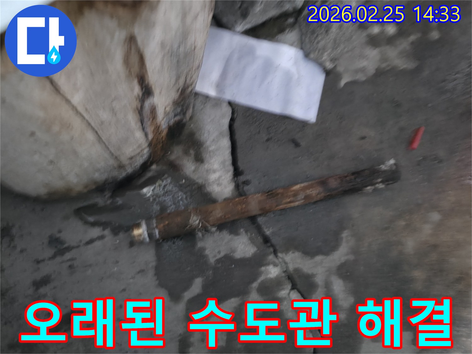 오래되어 녹슬고-파열된 수도관이-젖은 바닥에 놓여있는-누수 현장 사진입니다.