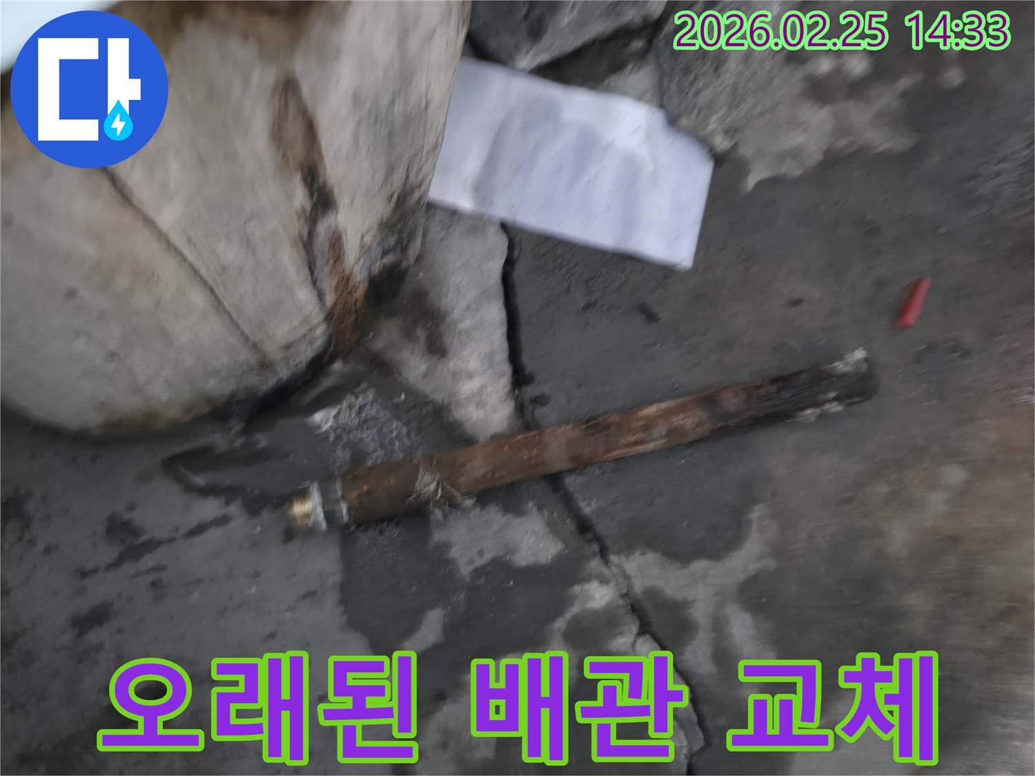오래되어 부식된-파열된 배관이-젖은 바닥에 놓여있는-누수 공사 현장 사진입니다.