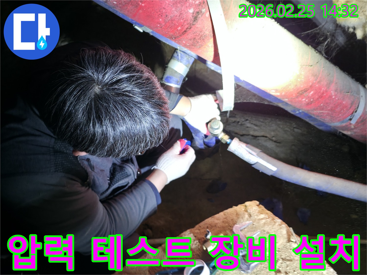 전문 누수 엔지니어가 어두운-협소한 공간에서 배관에 압력 테스트 장비를 설치하여-누수 지점을 정밀하게 탐지하고 있습니다-정확한진단-첨단장비활용