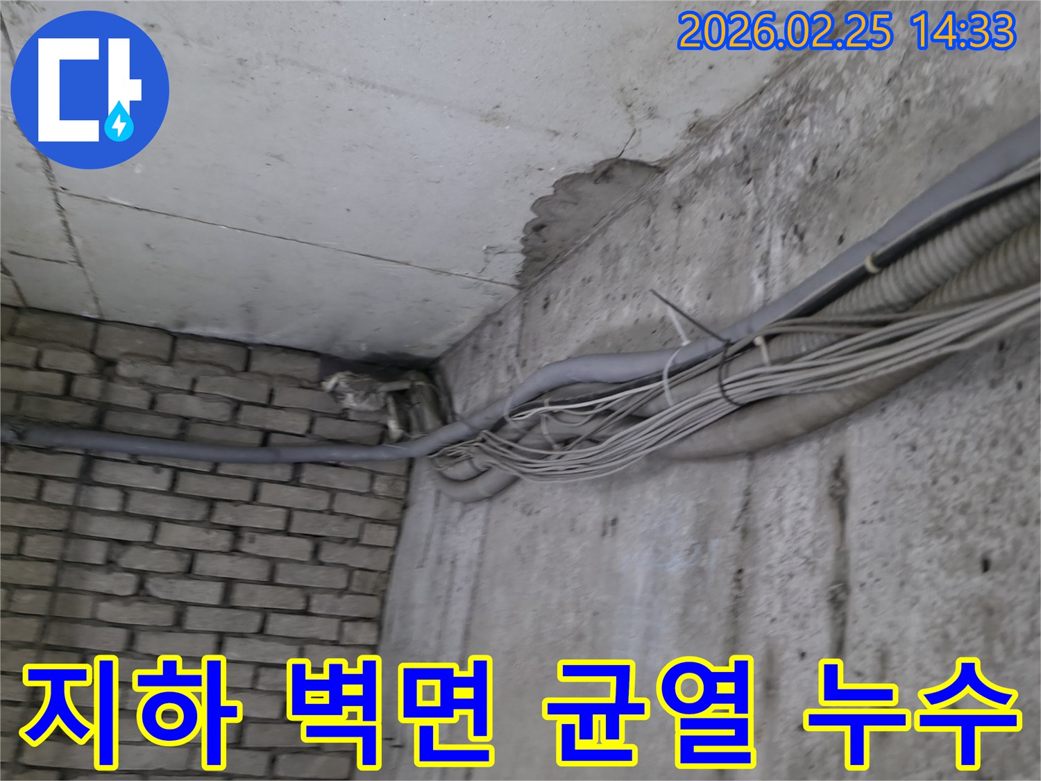 지하 벽면의-콘크리트와-벽돌 벽이 만나는-지점에서-발견된-오랜 누수로 인한-물자국과-균열 그리고-주변의 복잡한 배관