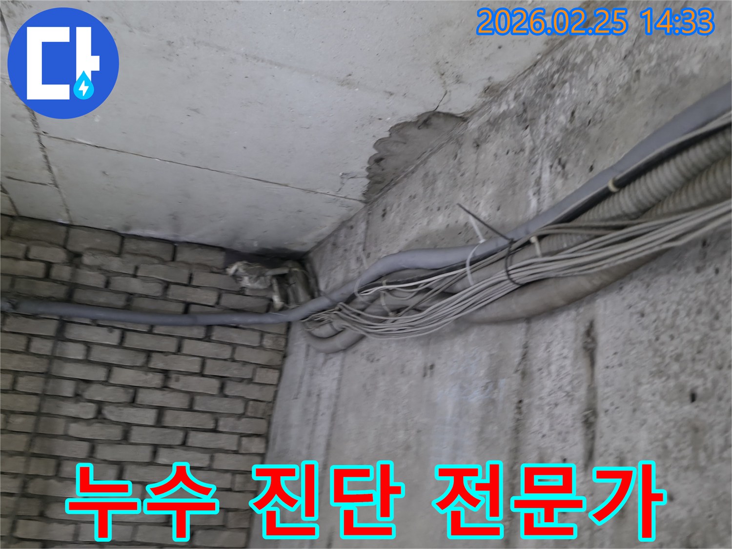 지하 벽면의-콘크리트와-벽돌 벽이 만나는-지점에서-발견된-오랜 누수로 인한-물자국과-주변의 복잡한 배관