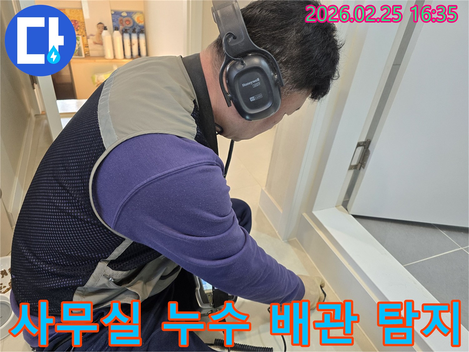 누수 엔지니어가-청음식 탐지 장비로-사무실 바닥의-숨겨진 배관 파열음을-정밀하게 듣고 있습니다