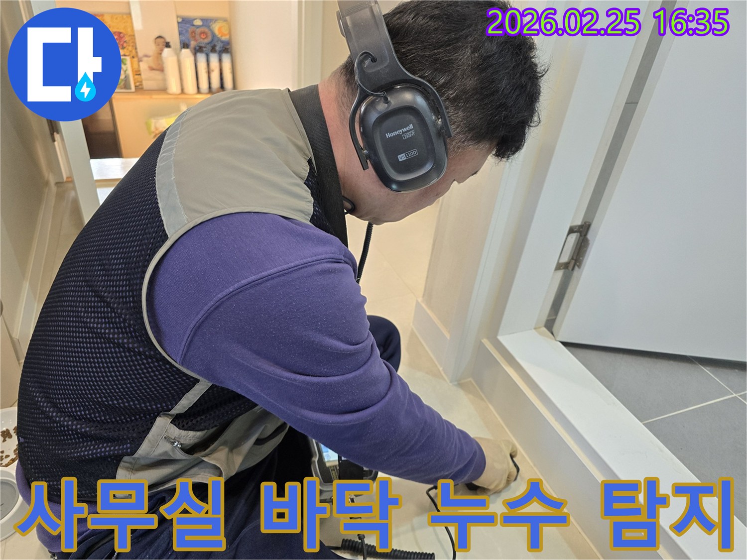 누수 엔지니어가-청음식 탐지 장비로-사무실 바닥의-숨겨진 배관 파열음을-정밀하게 듣고 있습니다