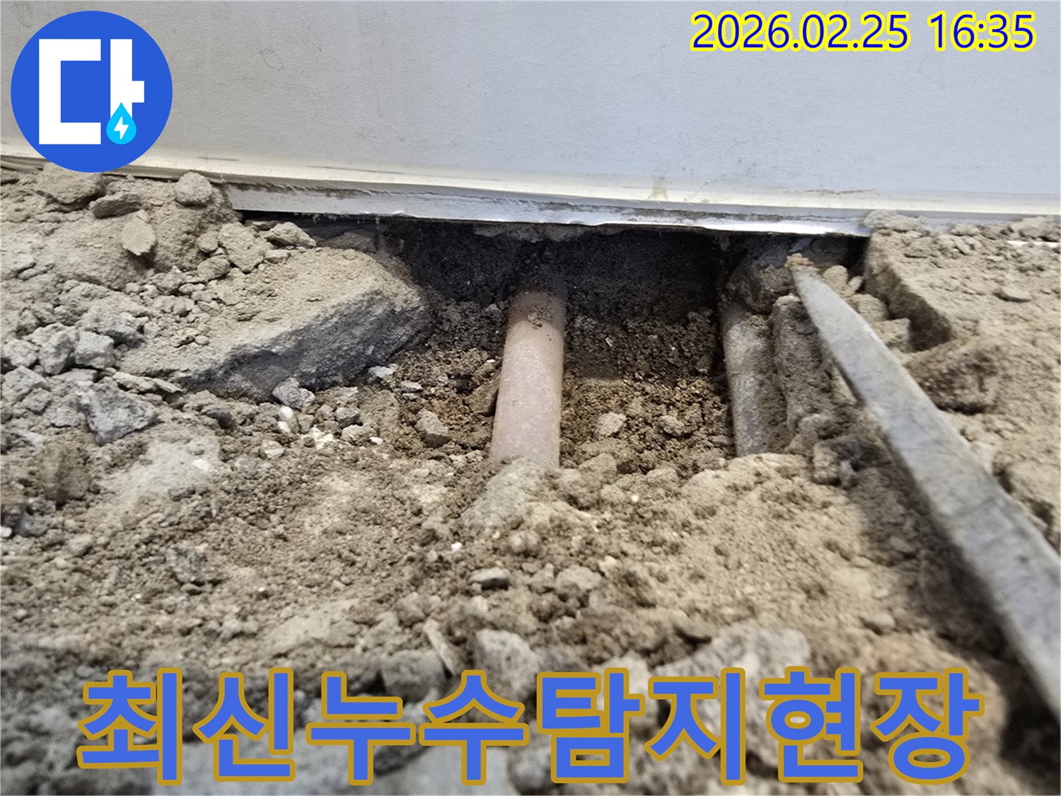 이-사진은-최신-누수-탐지-장비를-활용하여-땅을-파내어-매립된-배관의-누수-지점을-확인하는-작업-현장을-보여줍니다