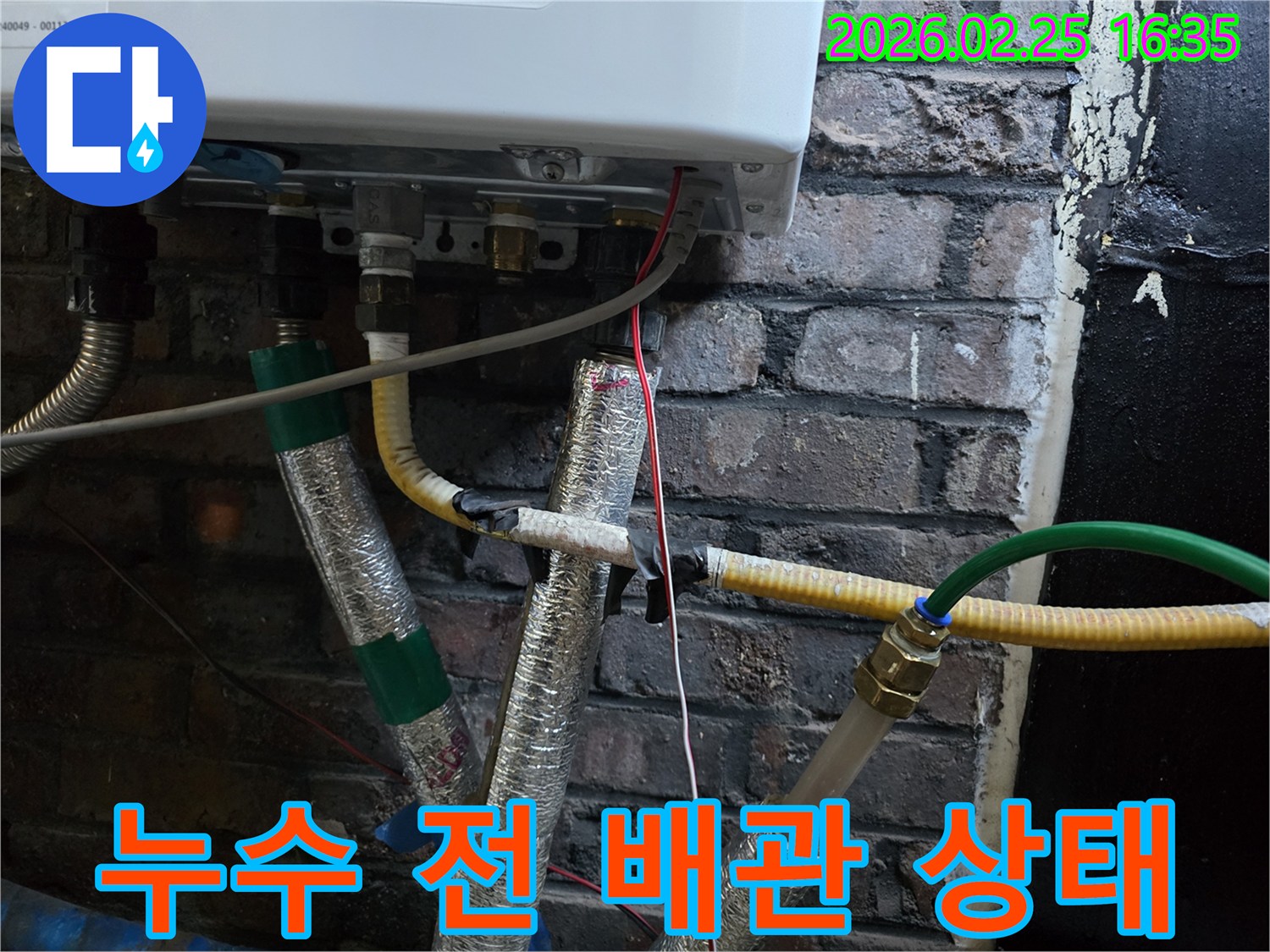 이 이미지는-보일러 하단에-연결된-다양한 배관과-전선-그리고-단열재가-감싸진-모습을-보여주며-누수 발생 전-또는-누수 확인 직후의-배관 상태를-나타냅니다.