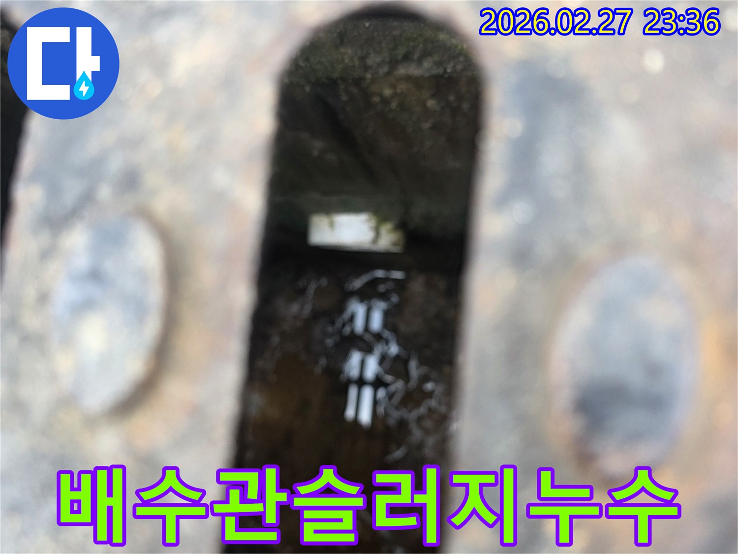 녹슨-철제-배수구-아래-고인-물과-물속에-비치는-배관-슬러지가-보이는-누수-현장
