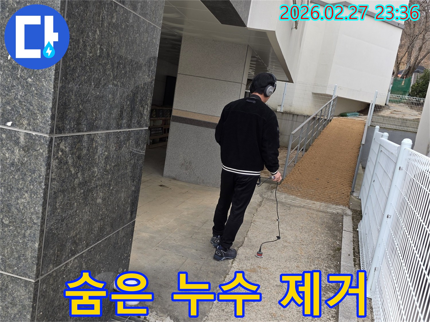 누수 엔지니어가-청음식 탐지기로-건물 외부의-숨은 누수 지점을 찾아내어-완벽한 제거를 돕는 모습