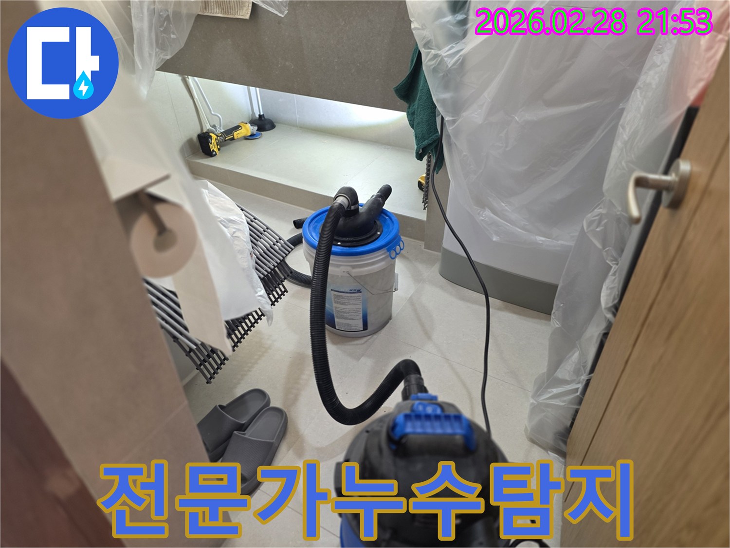 이 이미지는 누수 탐지 작업을 통해-전문가에게 맡겨야 하는 이유를 보여주듯-주변을 비닐로 보양하고-습식 청소 장비를 설치하는 모습을 보여줍니다.
