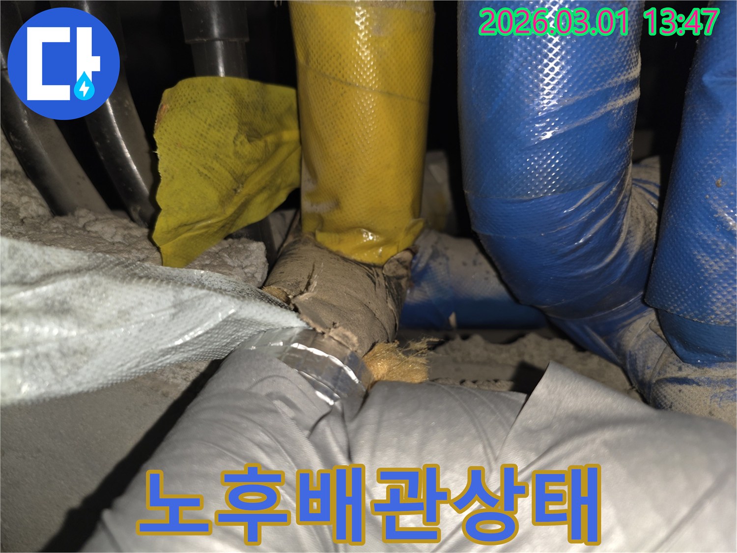 손상된 배관 단열재를 통해-습기 침투 및 누수 가능성을 시사하는 현장 사진입니다.