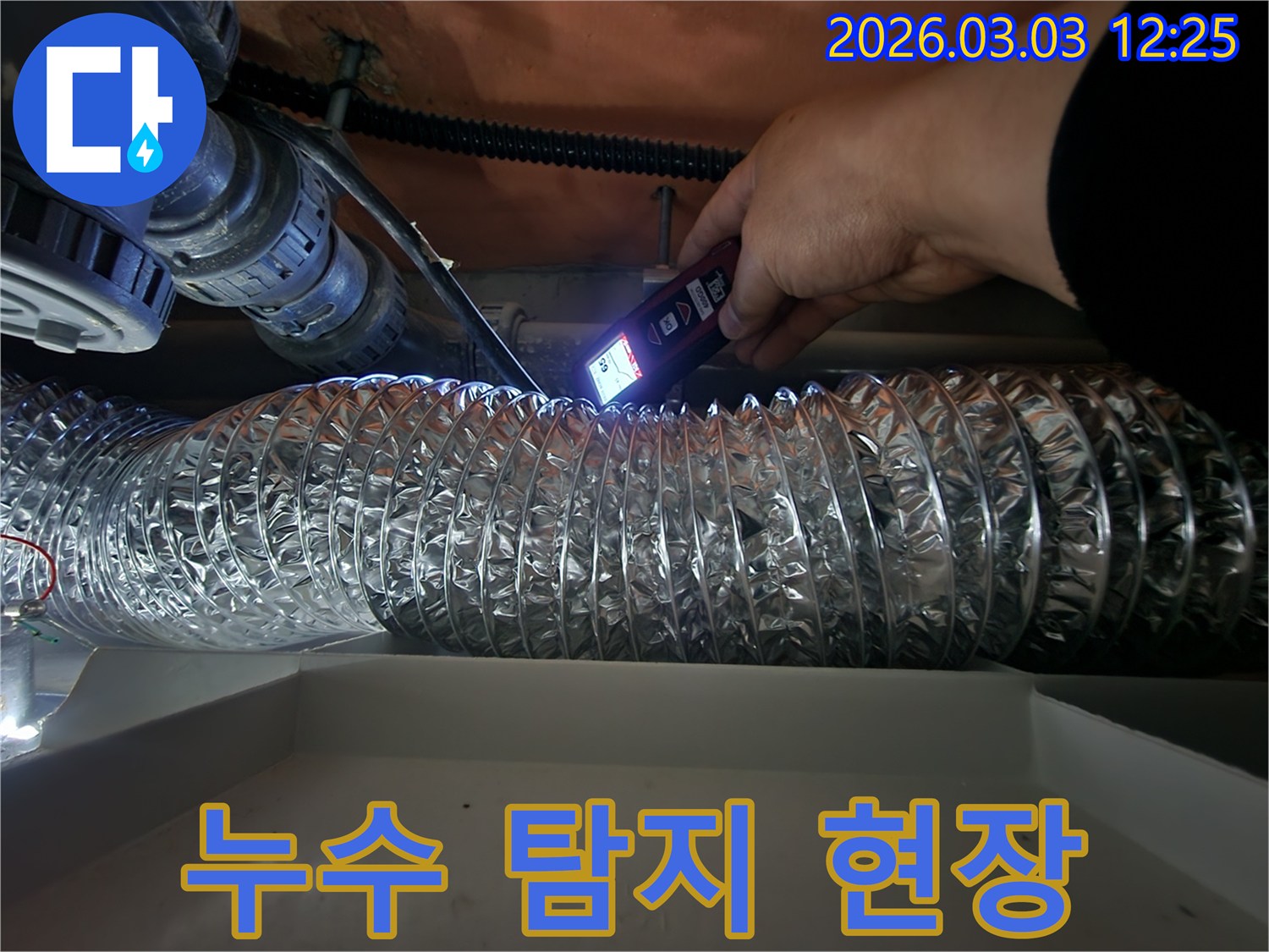 누수 진단 전문가가-특수 장비의 불빛으로-어두운 천장 내부의-배관 상태를 면밀히 살피는 모습