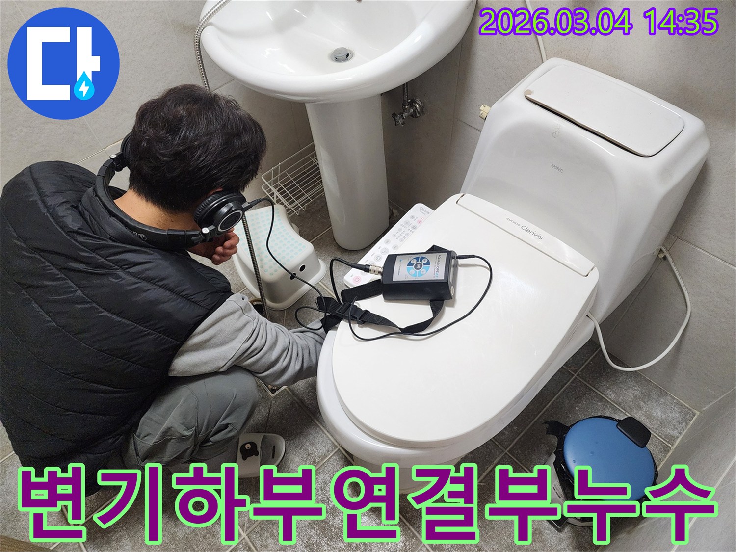 엔지니어가-헤드폰을-착용하고-변기-하부-배관-연결부의-누수-여부를-청음식-탐지기로-정밀하게-진단하는-모습