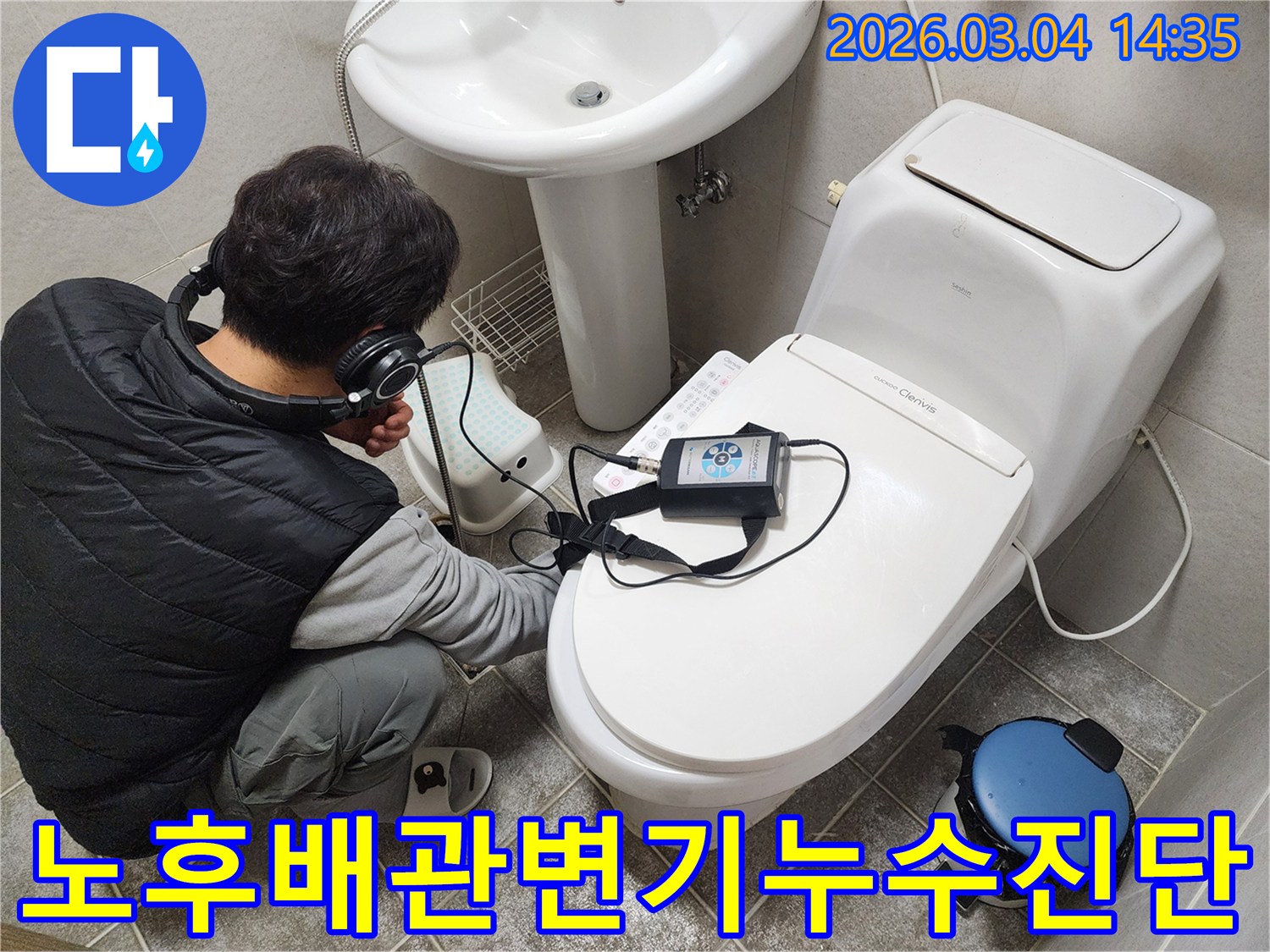 전문-엔지니어가-헤드폰을-착용하고-오래된-주택-화장실-변기-주변의-노후-배관-누수를-정밀하게-진단하는-모습