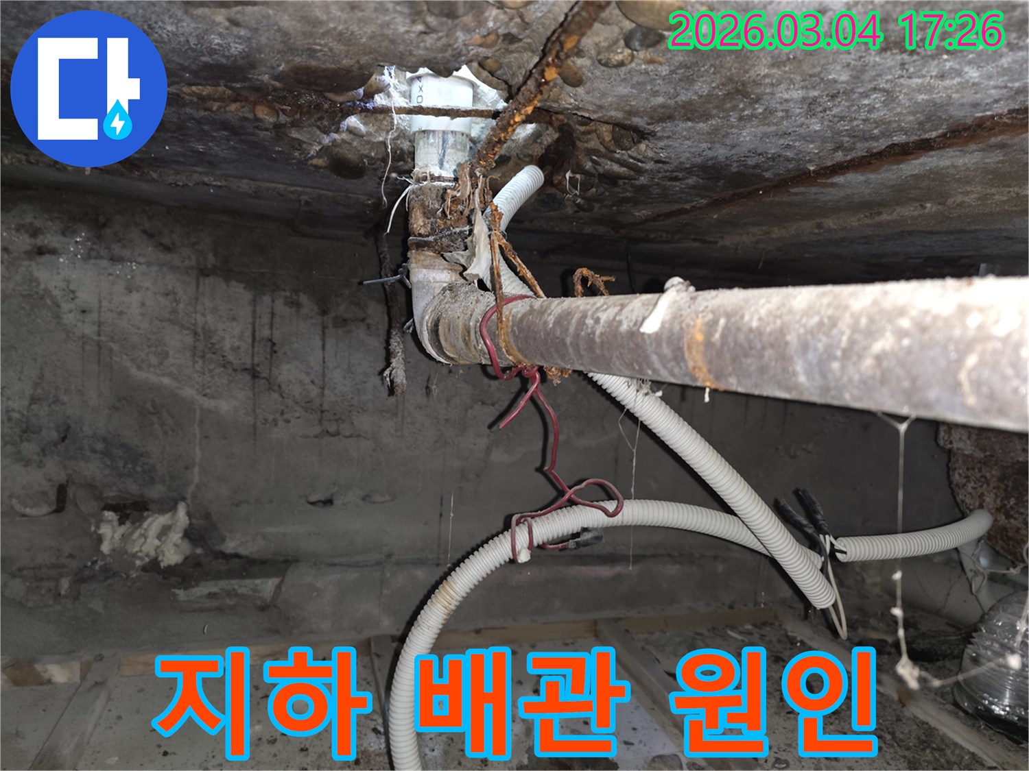 오래된 건물-지하 배관의-심각한 부식으로-인한 누수 현장을-전문가가-정밀하게-진단하고-원인을 분석하는-모습을-담은 사진입니다