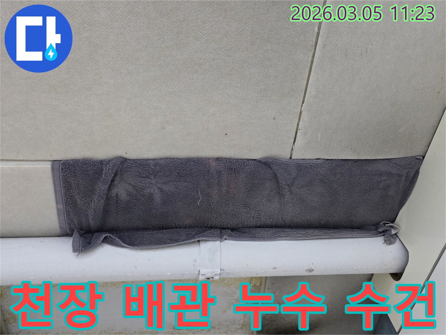 누수 지점에서 물이 떨어지는 것을-수건으로 받아내고 있는 상황-고객님의 빠른 대처가 돋보입니다