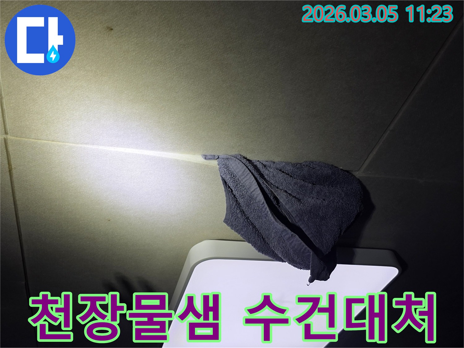 천장에서-물이-새어-나와-수건으로-받고-있는-긴급-누수-상황을-보여주는-이미지