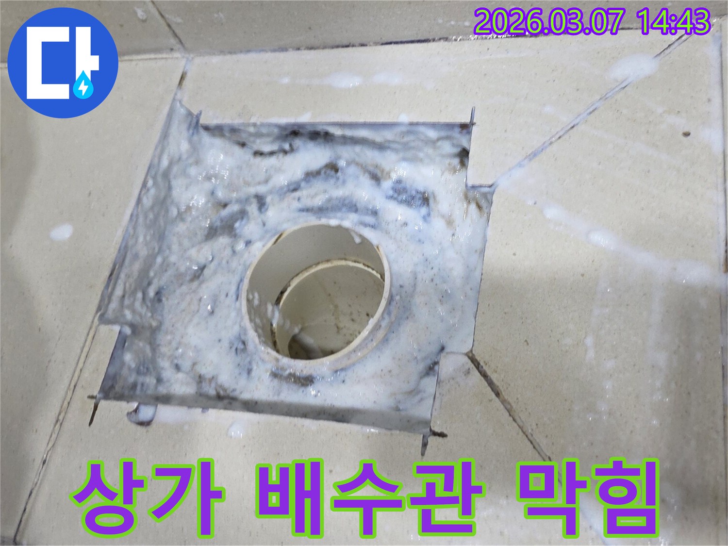 욕실 배수구에서 하얀 거품이 넘쳐흐르는-하수구 막힘의 명확한 증거를 보여줍니다.